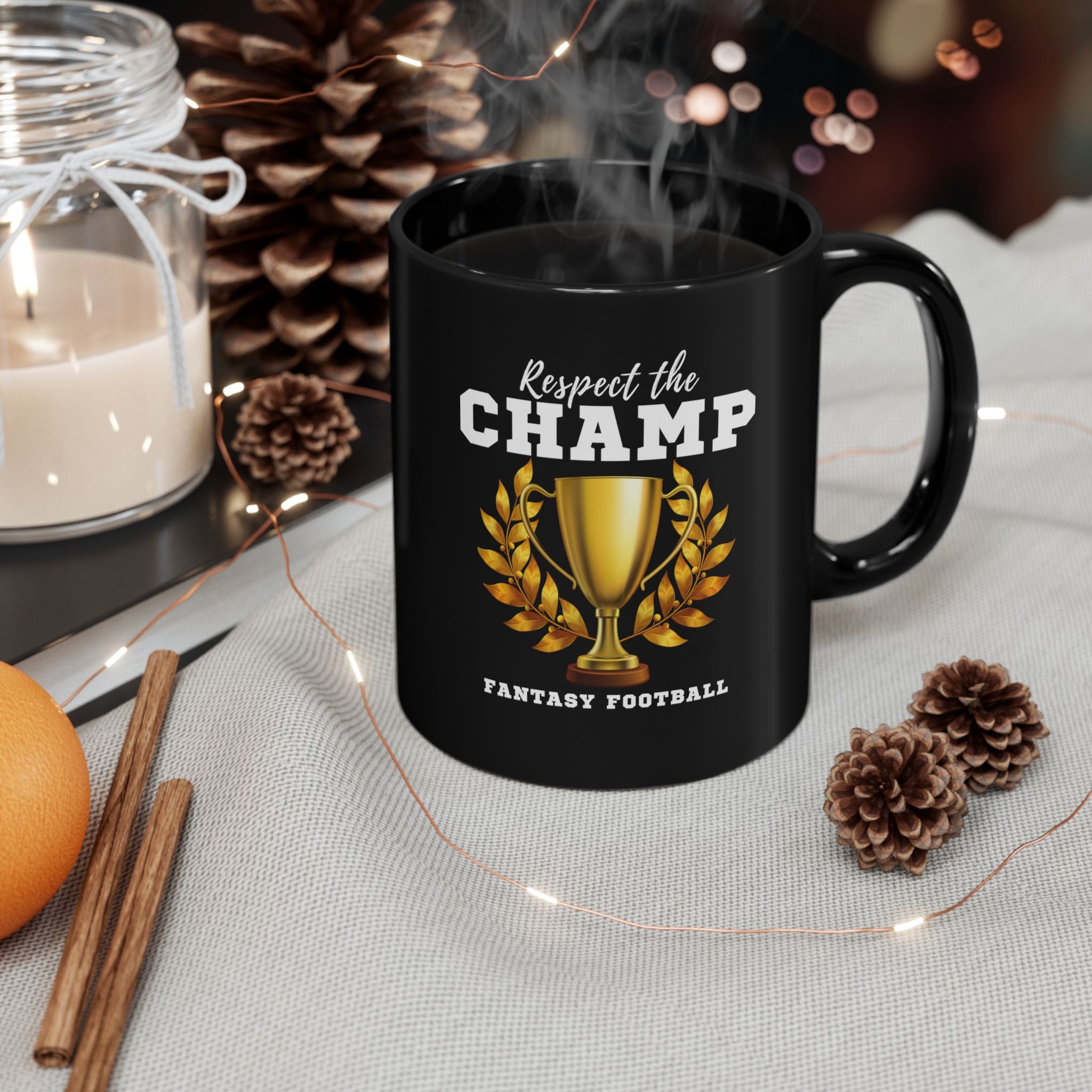 Black mug with 'Respect the Champ' fantasy football design on a table with decorative items.