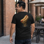 Man wearing a black t-shirt with a hot dog graphic on the back, standing outdoors.