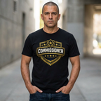 Man wearing a black t-shirt with 'Commissioner' logo in an urban setting