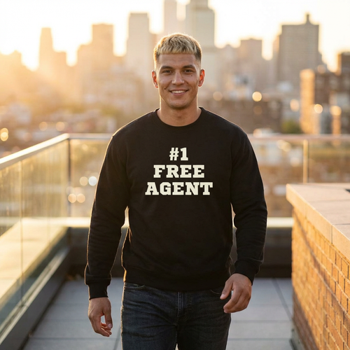 Man wearing a black sweatshirt with '#1 FREE AGENT' text on a rooftop with cityscape background
