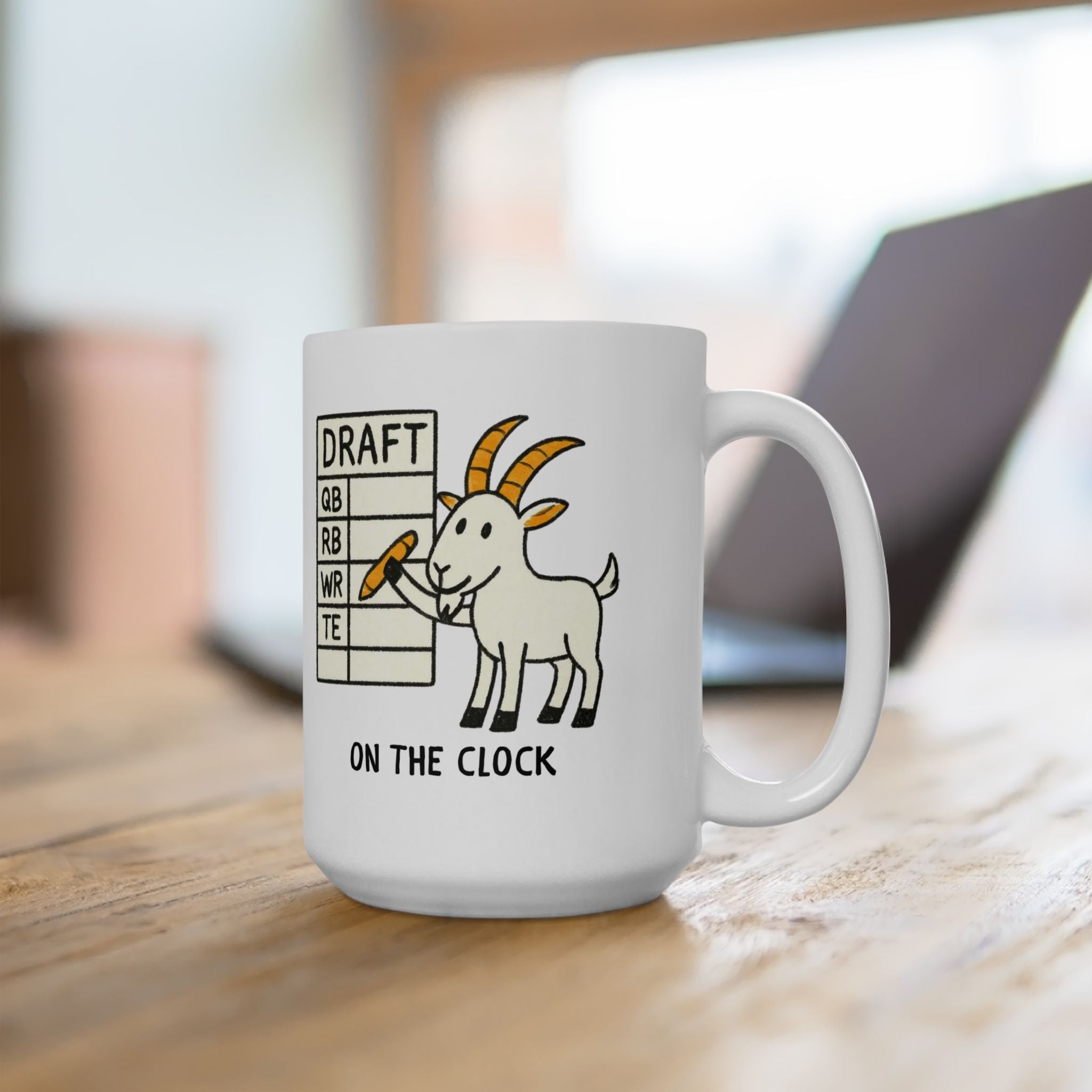 White mug with a goat illustration and text on a wooden surface